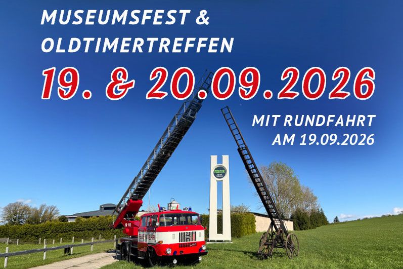 Vor dem HTC-Pylon stehen zwei historische Feuerwehrfahrzeuge